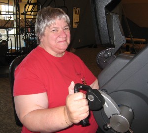 Strengthening her muscles on the ergonometer (arm bike).