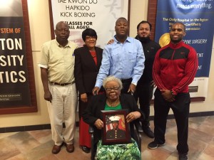 Ruben with his family, Trainer Ryan (red & black jacket), and Sanori (Ruben's aid who is like family). Thema (seated) holds a photo of Ruben's brother who is on active duty.