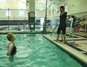 Janice follows Instructor Jennifer during Aquatic Pilates class.