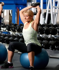 Engage multiple muscle groups with free weights. Extra points for balancing on fitness ball!