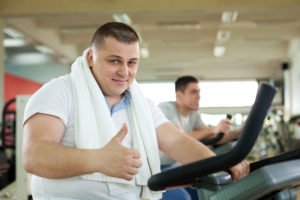 Overweight Man On Exercise Bike